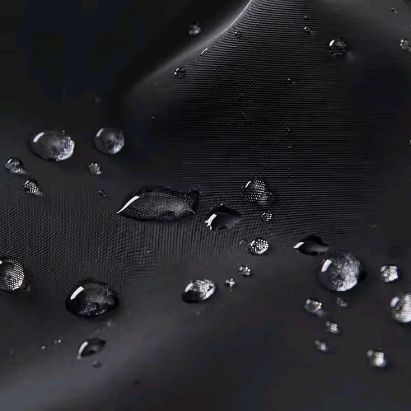 Gouttes d'eau sur le tissu imperméable noir en polyester de l'imperméable pour chien AventureCanine