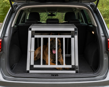 Cage de transport AventureCanine en aluminium pour chien installée dans le coffre d'une voiture avec un berger malinois
